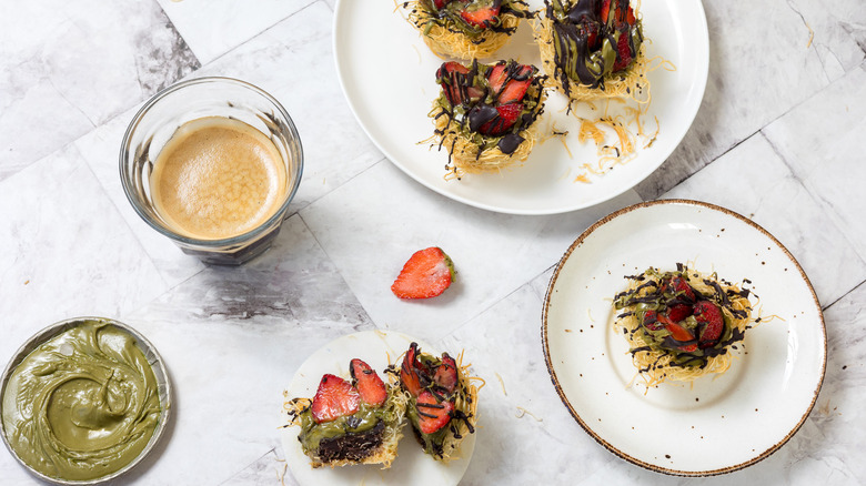 Dubai chocolate strawberry cup cut in half on small plate