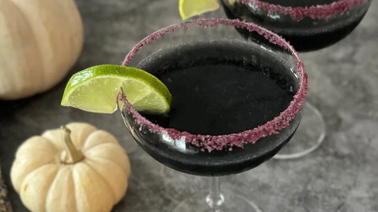 Black Margarita with purple salt rim on grey table