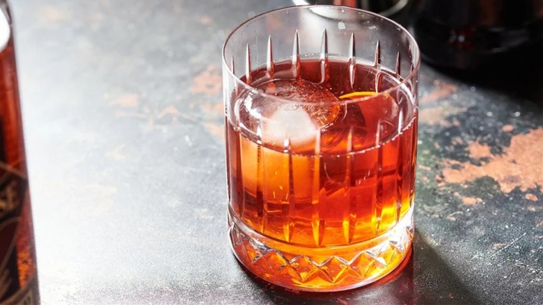 Boulevardier cocktail with ice on a worn countertop