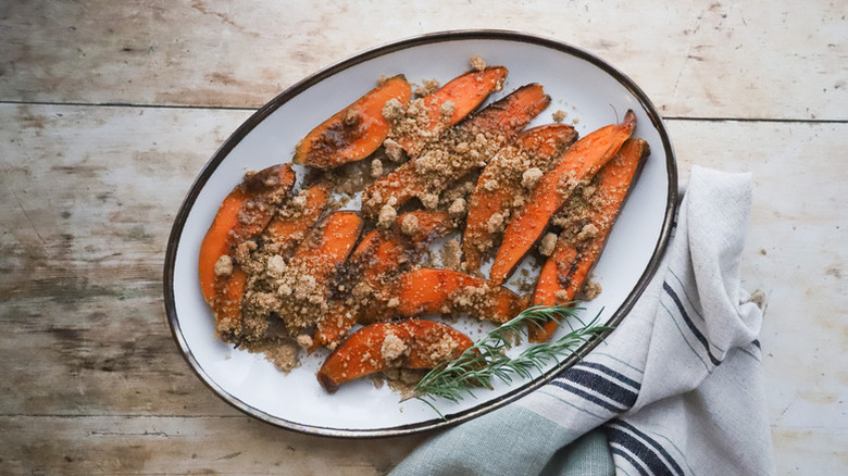 Streusel-topped roasted sweet potatoes on a white serving plate