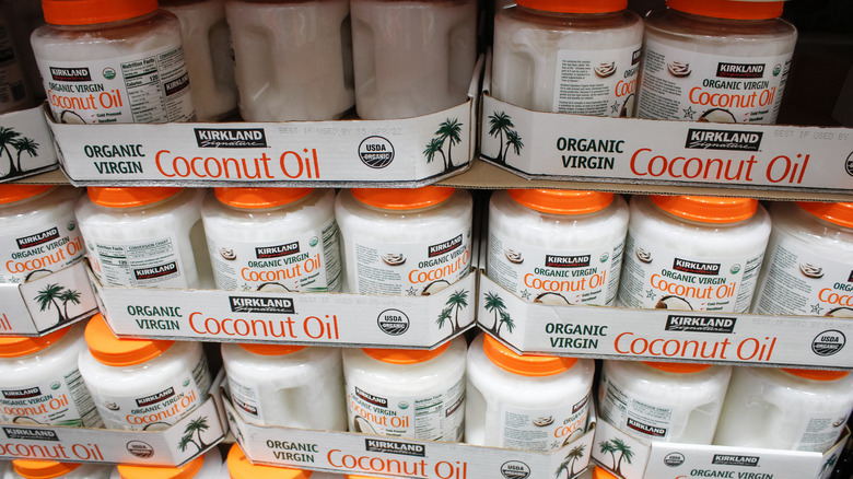 Large plastic containers of coconut oil stacked in rows