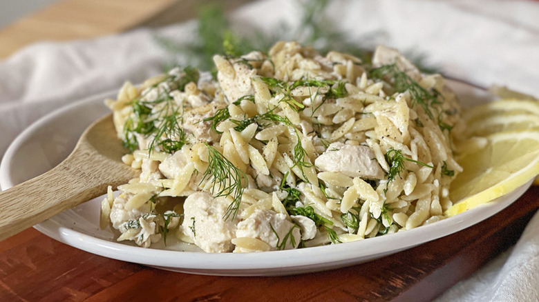 Plate of chicken orzo salad topped with fresh dill