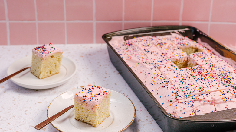 two slices of Mexican pink cake on small plates with large cake pan in background