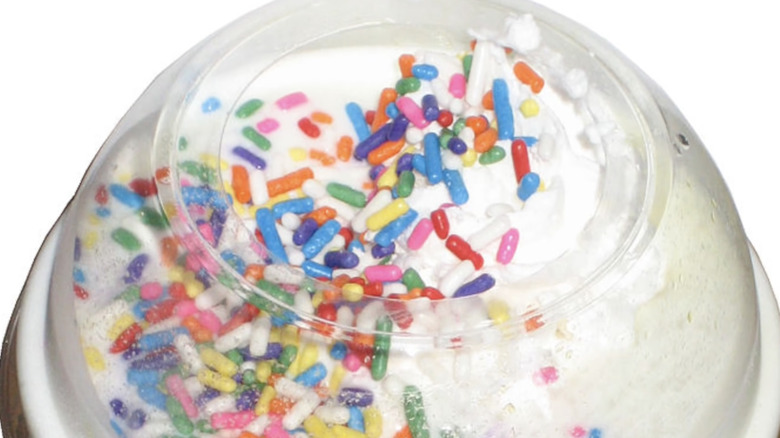 A cupcake shake in a takeaway cup with colored sprinkles