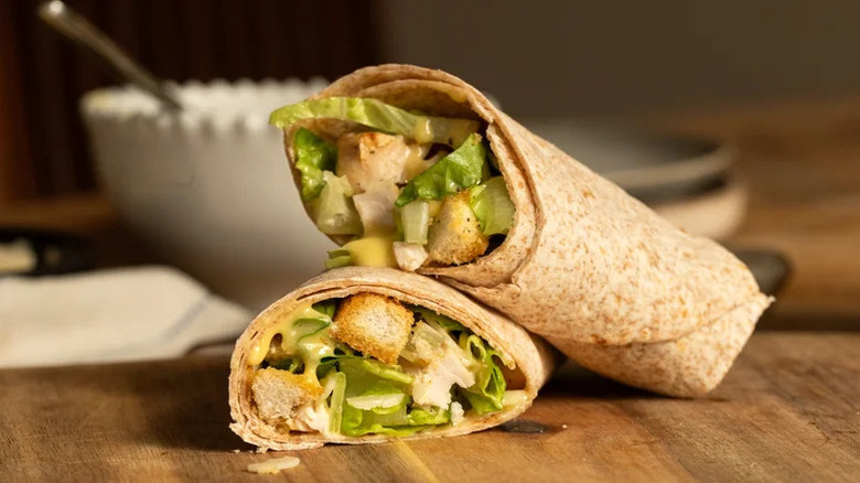 Easy Chicken Caesar Wrap with Homemade Croutons on wooden cutting board