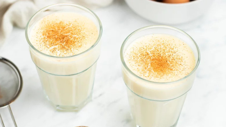 Eggnog in a tall glass dusted with cinnamon