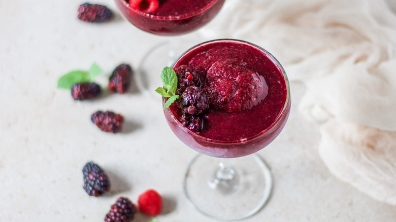 Red wine slushie cocktail garnished with fresh blackberries and mint sprigs