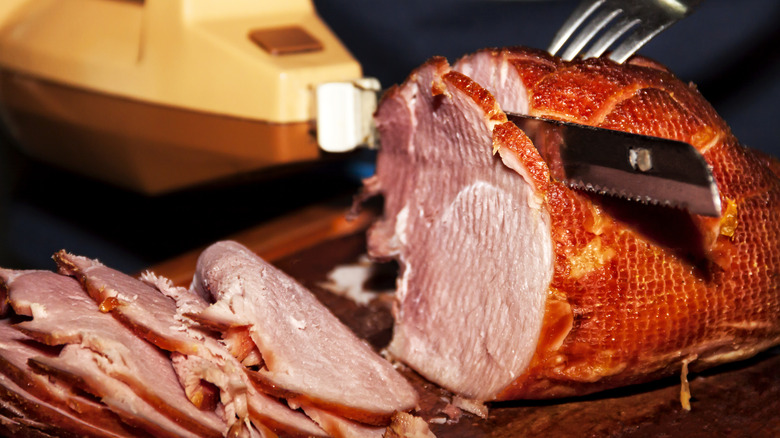 Carving baked ham with electric knife