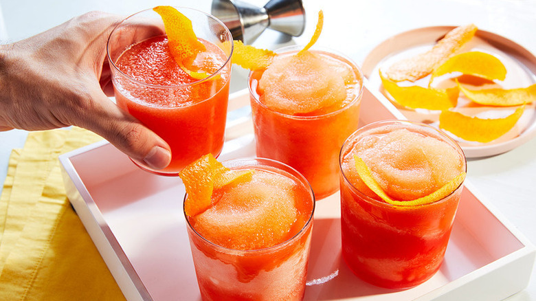 Four frozen negroni cocktails garnished with orange peel