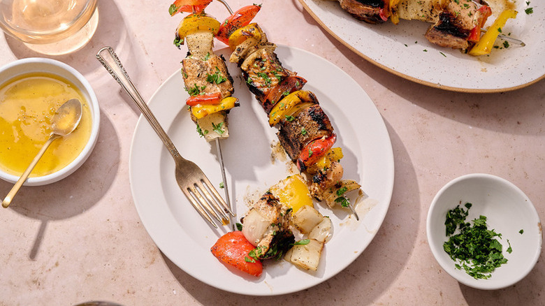 Salmon and vegetable skewers on white plates