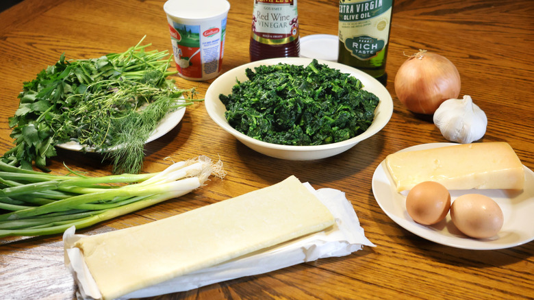spinach and cheese pie ingredients laid out on a wooden table