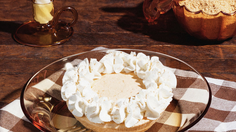 Crumbl Pumpkin Cream Pie on a glass plate on a wooden table