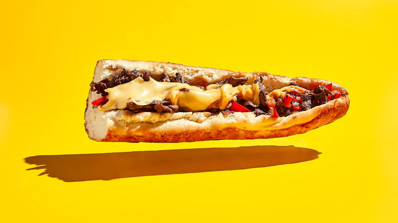 A cheesesteak floating on a yellow background