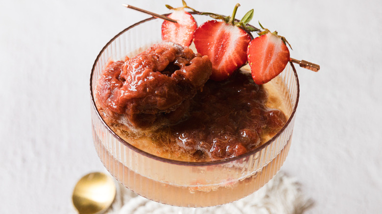 Coupe glass with rhubarb strawberry sorbet, sparkling wine and strawberries