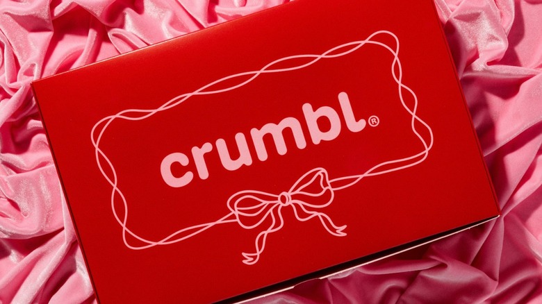 A Crumbl Valentine's Day red box on pink fabric