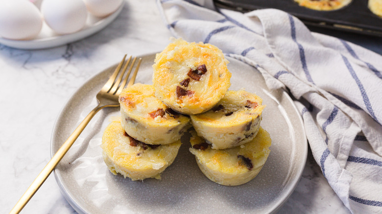Mount of egg bites with muffin pan and eggs in background