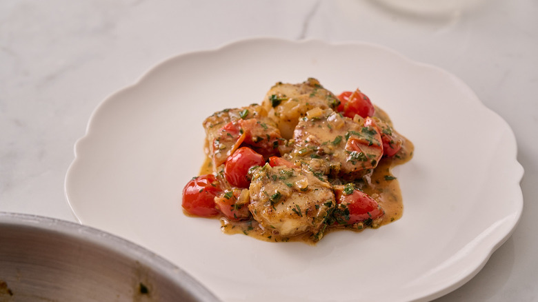 Scallops Provencal on a white plate