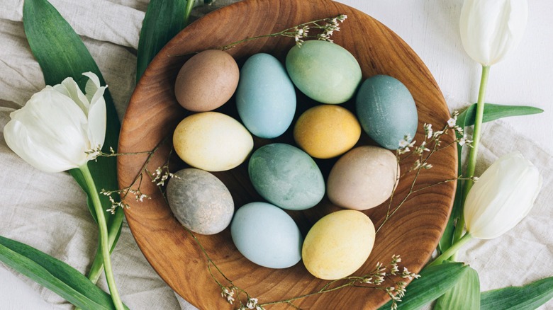 Overview of naturally-dyed Easter eggs in a wooden bowl