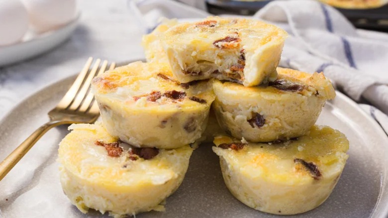Bacon and gruyere egg bites stacked on white plate