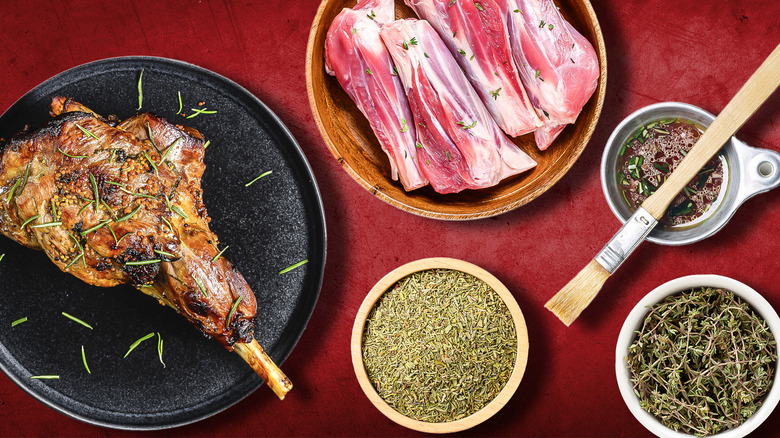 A leg of lamb surrounded by herps and sauce