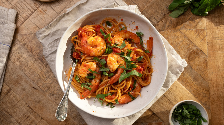Garlic shrimp pasta in white bowl with fork