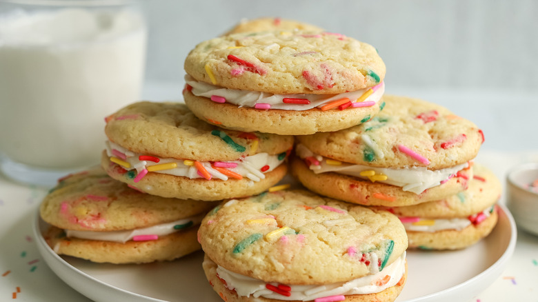 Birthday cake sandwich cookies stacked on plate