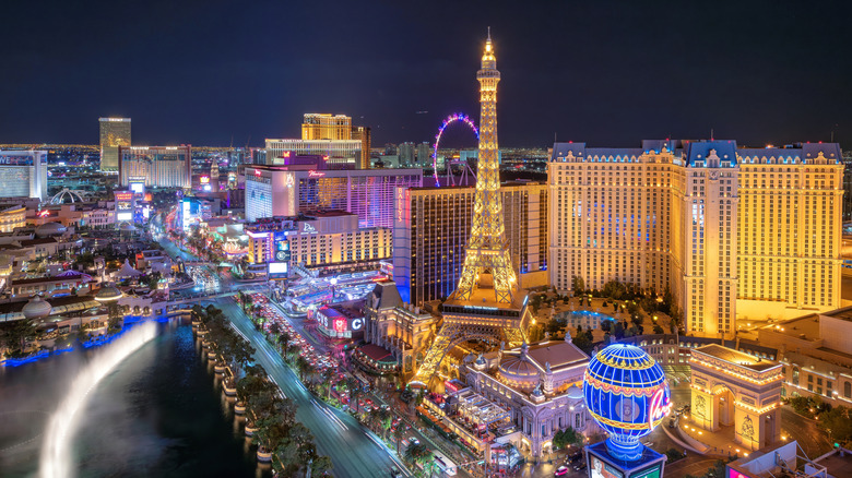 A night image of Las Vegas with the bright lights, hotels, and the model Eiffel Tower