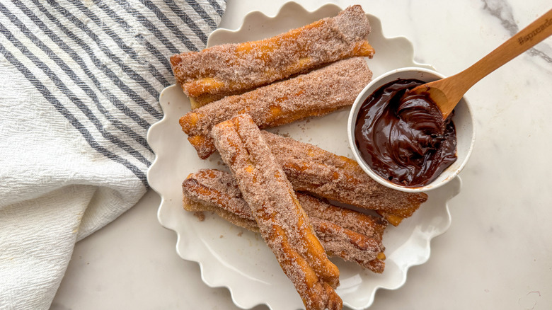 Churros on plate with bowl of chocolate sauce