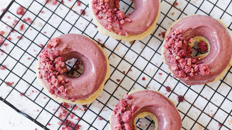 Raspberry donuts on cookie drying rack