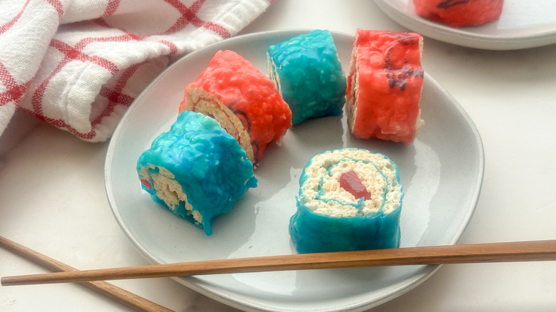 plate of candy sushi next to checkered cloth and pair of chopsticks