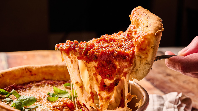 deep dish pizza slice lifted out of pan