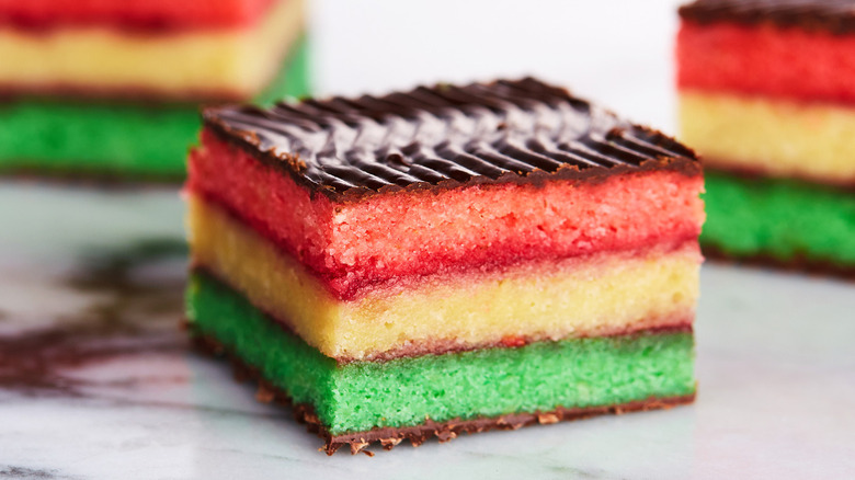 Close up of layered Italian rainbow cookie with chocolate topping