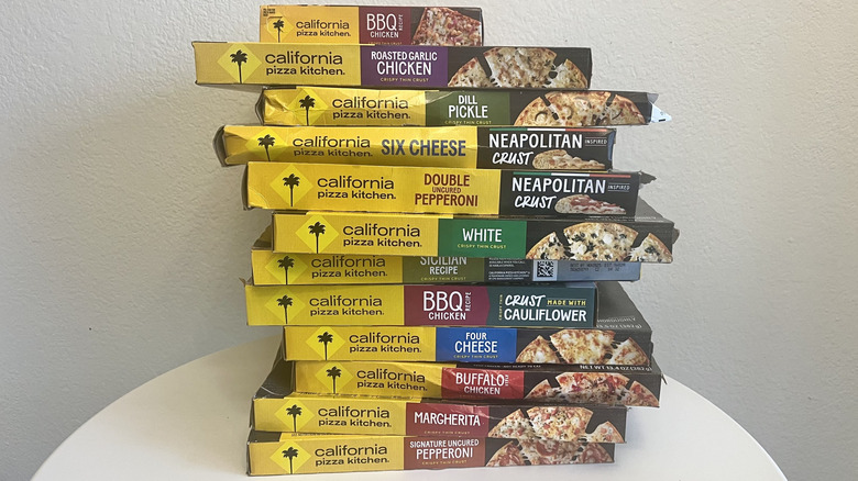 A stack of different boxes of CPK pizza on a table