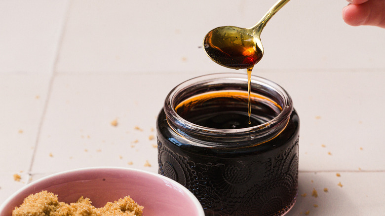 Syrup dripping from a spoon into a jar