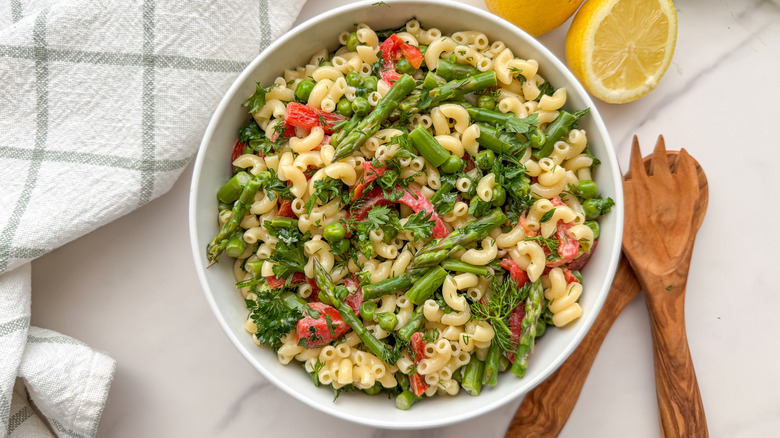 Macaroni salad with asparagus in white bowl