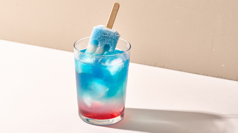 Red, white, and blue Bomb Pop cocktail on table