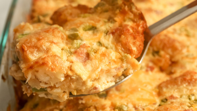 scooping cheesy jalapeño popper tater tot casserole