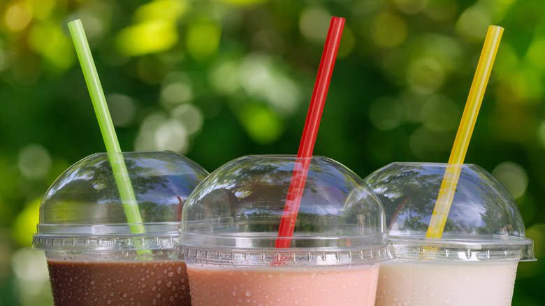 top of 3 drinks in plastic cups with lids with straws