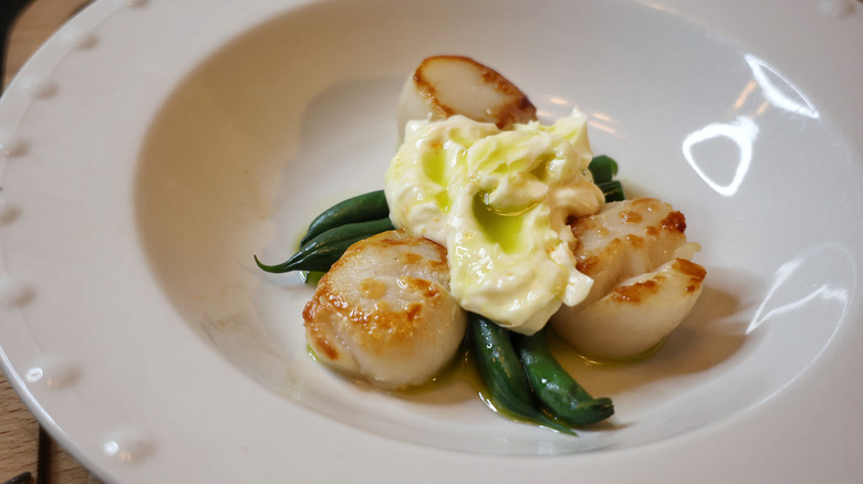 Sydney's lightly seared scallops with crisp verts, basil oil, and orange-ginger compound butter