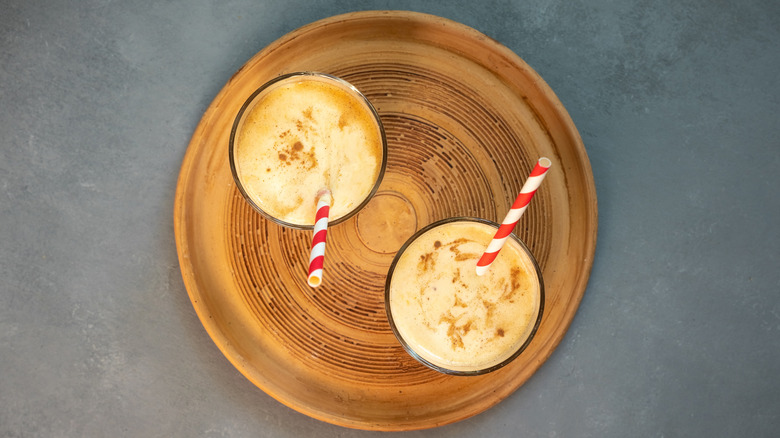 gold milkshakes on wood board with spice on top