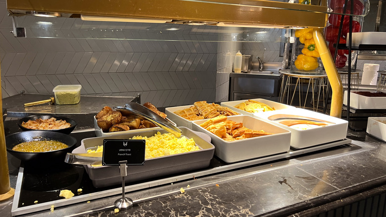 A breakfast buffet with scrambled eggs and waffles