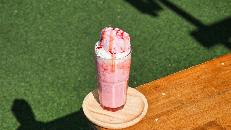 strawberry milkshake on a wood table near grass