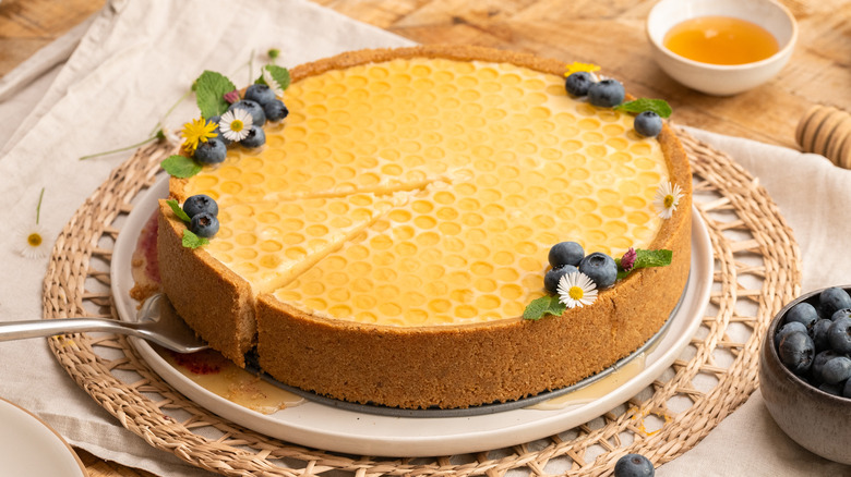 a slice cut from blueberry elderflower honeycomb pie on top of a plate