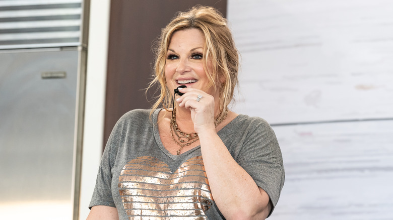 Trisha Yearwood holding mic on cooking stage with refrigerator