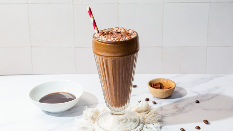 Glass with frothy egg cream with red and white straw