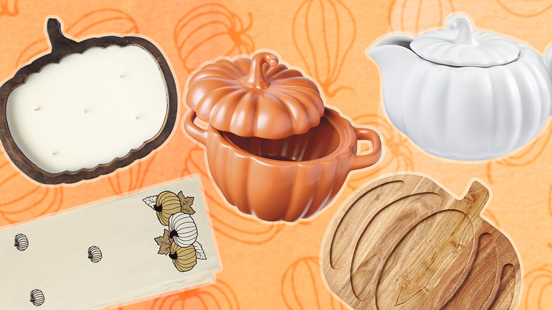 Pumpkin-themed dishes, candle, board, and napkin on an orange background