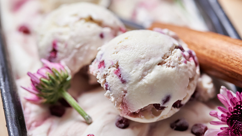 Close up of scoops of pomegranate ice cream with pink edible flowers