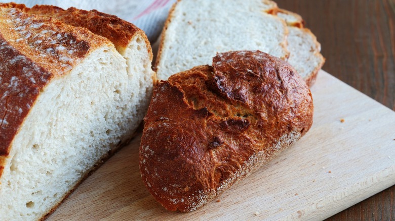 The heel cut off a loaf of crusty bread on a wooden cutting board