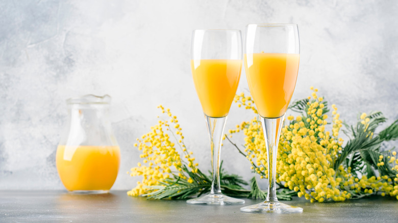 mimosas in flute glasses with orange juice