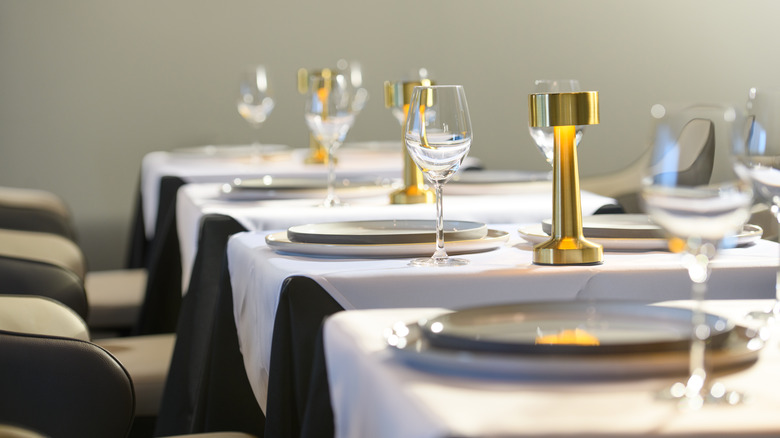gold lamps and white plates on fine dining restaurant table